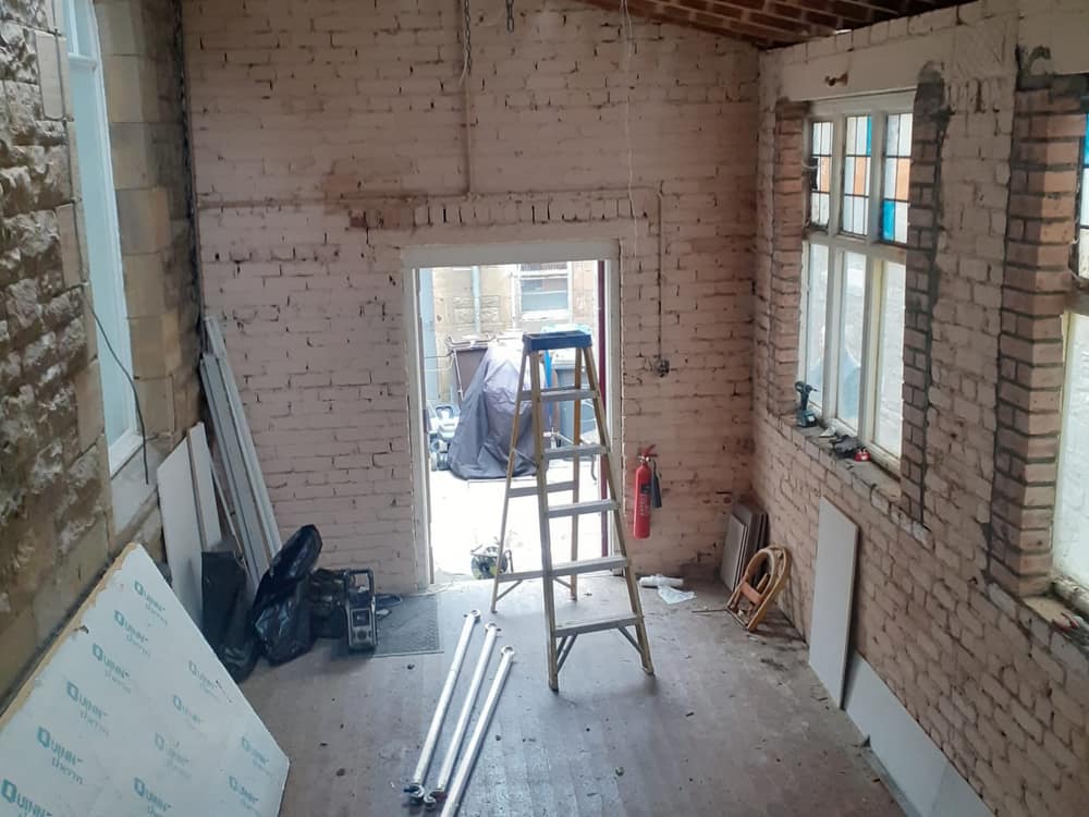 Stripped-out room with a doorway opening to the rear yard
